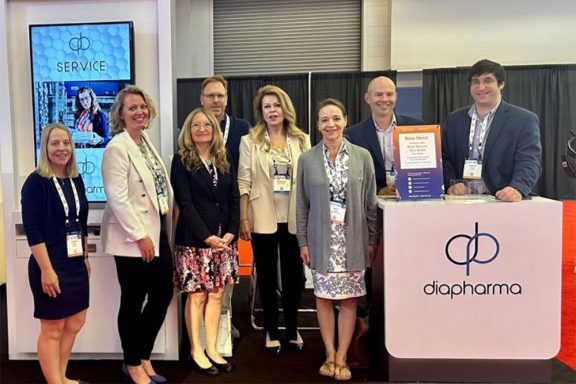 Team photo next to diapharma booth at a convention